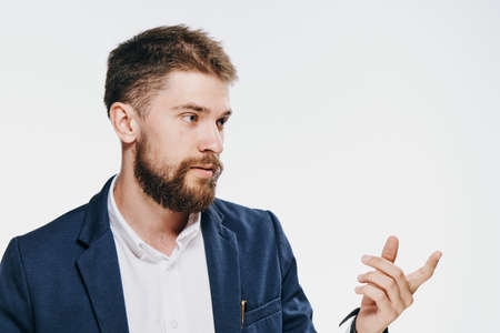 Business man with a beard on a white isolated background shows on an empty space.の写真素材