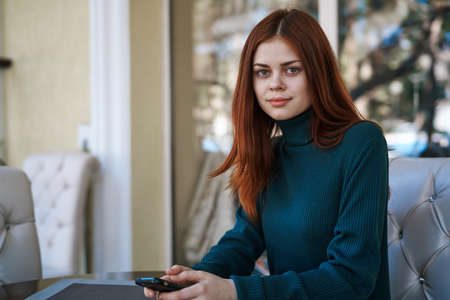 Beautiful young woman sitting in a cafe on the street.