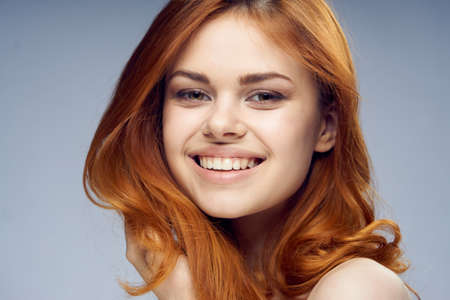 Beautiful young woman on gray background portrait.
