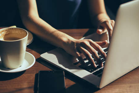 Beautiful young woman working at computer in cafe.の写真素材