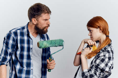 Young guy with beard and beautiful woman on white isolated background, repair, housework.の写真素材