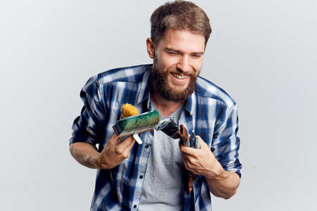 Young guy with a beard on a white isolated background holds a tool for repair.の写真素材