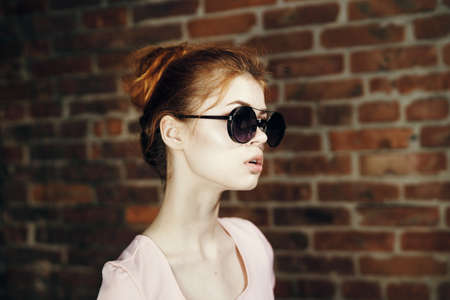 Beautiful young woman in sunglasses on the street.の写真素材