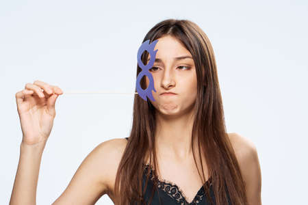 Beautiful young woman on white isolated background holds a paper accessory for parties.の写真素材