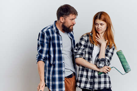 Young guy with beard and beautiful woman on white isolated background, repair, housework.の写真素材