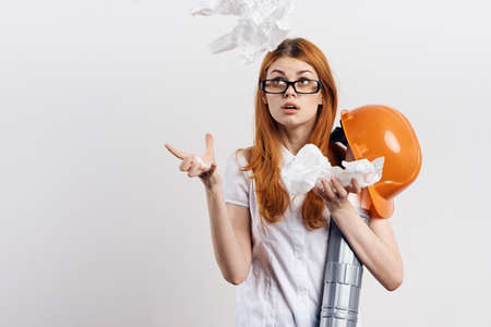 Beautiful young woman engineer on white isolated background holds blueprints.