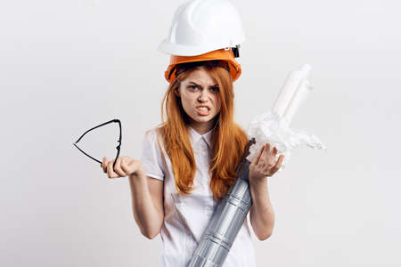 Beautiful young woman engineer on white isolated background holds blueprints.の写真素材