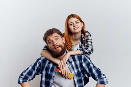 Beautiful young woman and guy with a beard on white isolated background, repair, housework, painting, building materials.の写真素材