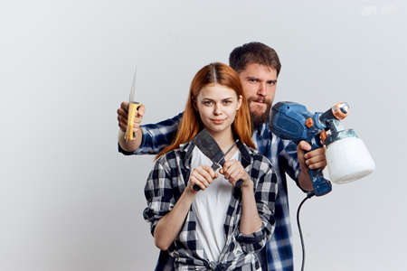Beautiful young woman and guy with a beard on white isolated background, repair, housework,...
