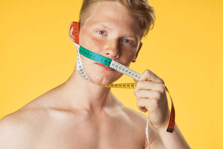 Young guy athlete on a yellow background, portrait, sport, fitness.の写真素材