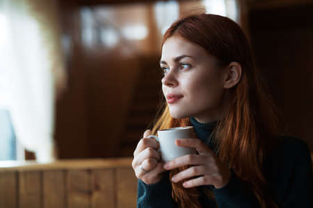 Beautiful young woman drinks coffee in a cafe.の写真素材