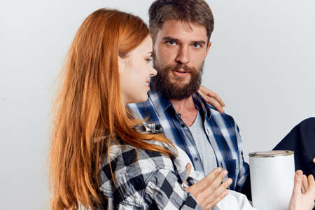 Young beautiful woman and guy with beard on white isolated background, repair, building materials, tools.の写真素材