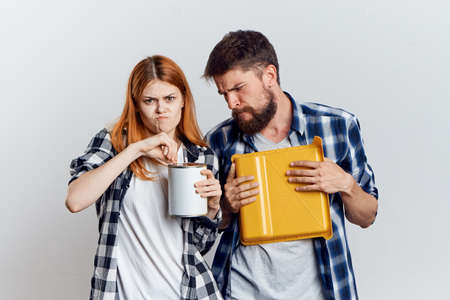 Young beautiful woman and guy with beard on white isolated background, repair, building materials, tools.の写真素材