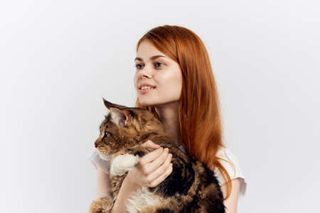 Beautiful young woman on white isolated background holds a cat, an allergy.の写真素材