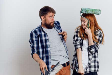 Young beautiful woman and guy with a beard on white isolated background, repair, construction tools.の写真素材