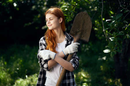 Young beautiful woman running in the garden in the summer, gardener.の写真素材