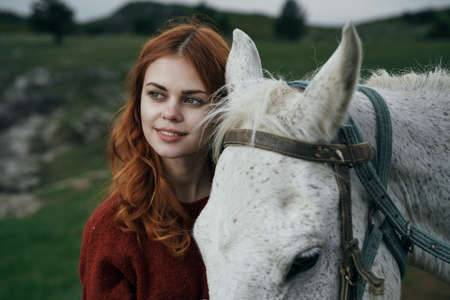 Young beautiful woman walking in the mountains with her horse.の写真素材