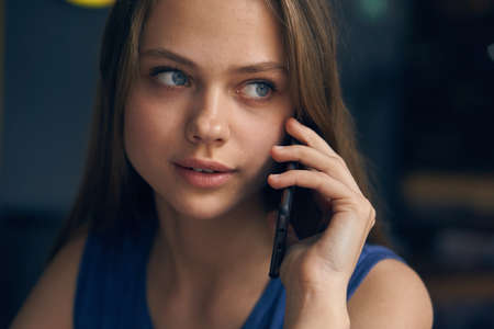 Young beautiful woman calls by phone in cafe.の写真素材
