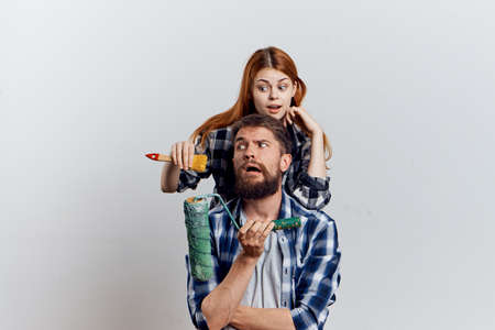 Young beautiful woman with a guy with a beard on white isolated background, repair, construction tools.の写真素材