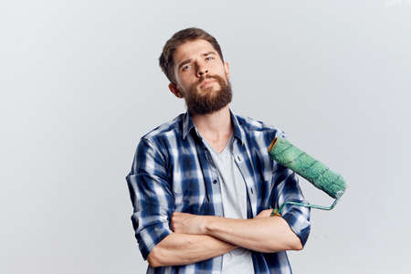 Young guy with a beard on a gray background holds a rollerの写真素材