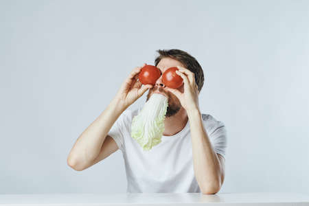 Young guy with beard on white isolated background, vegetables, vegan, healthy eating right.の写真素材