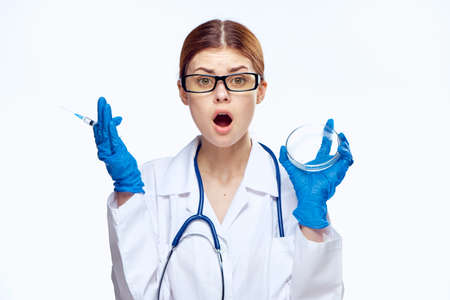 Young beautiful woman on white isolated background holds a syringe, doctor, medicine.の写真素材