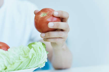 Young guy with beard on white isolated background, vegetables, vegan, healthy eating right.の写真素材