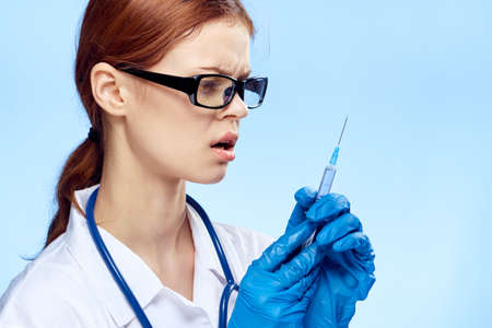 Young beautiful woman on a blue background, doctor, scientist, medicine.の写真素材