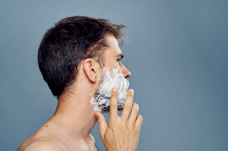 Man with a beard on a gray background in shaving foam.の写真素材