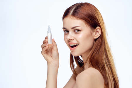 Beautiful young woman on white isolated background holds drops for eyes.の写真素材
