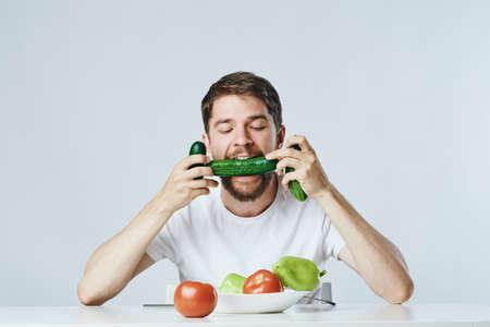 Man with a beard on a light background, vegetables, diet, vegetarianism, vegetarian.の写真素材