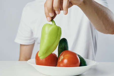Man with a beard on a light background, vegetables, diet, vegetarianism, vegetarian.