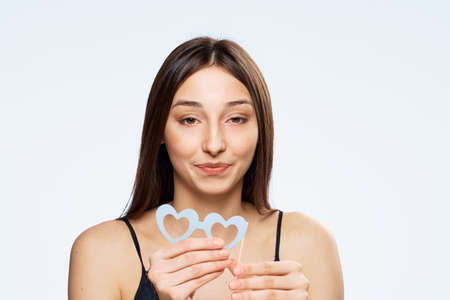 Beautiful young woman on white isolated background holds paper accessories for parties.の写真素材