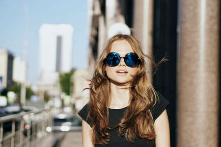 Beautiful young woman walking outdoors in city in summer.の写真素材