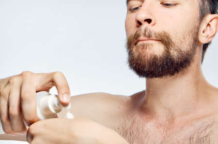 Man with a beard on white isolated background, cosmetic cream.の写真素材