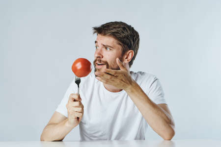 Man with a beard on a light background, vegetables, diet, vegetarianism, vegetarian.の写真素材