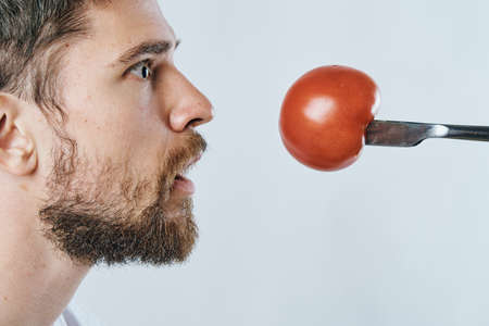 Man with a beard on a light background, vegetables, diet, vegetarianism, vegetarian.の写真素材