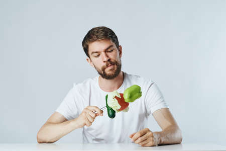 Man with a beard on a light background, vegetables, diet, vegetarianism, vegetarian.の写真素材