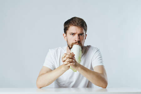 Man with beard on white isolated background eating salad, vegetables, diet, vegetarian.の写真素材