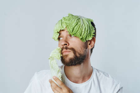 Man with a beard holds a salad, vegetables, vegetarian, diet.の写真素材