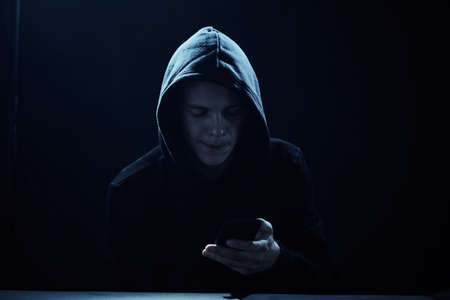 Male hacker hacks computer in darkness, laptop, screen, program.の写真素材