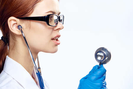 Young beautiful woman on white isolated background holds medical instruments, medicine.の写真素材