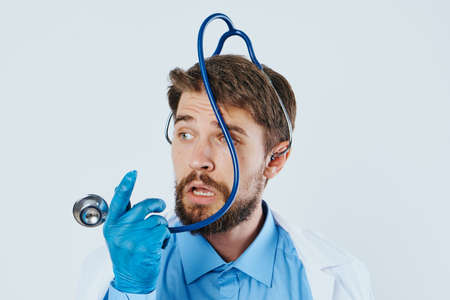 Man with a beard on a white isolated background holds medical instruments, doctor, medicine.の写真素材