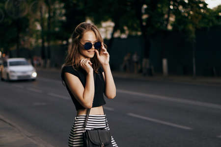 Young beautiful woman in sunglasses outside in the city walking.の写真素材