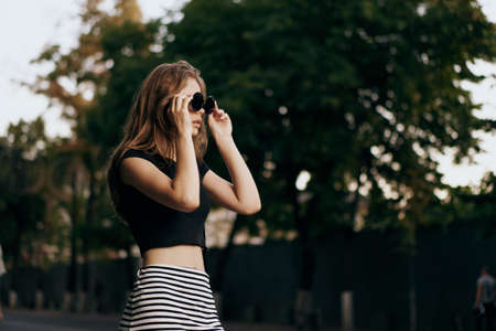 Young beautiful woman in sunglasses walking down the street.の写真素材