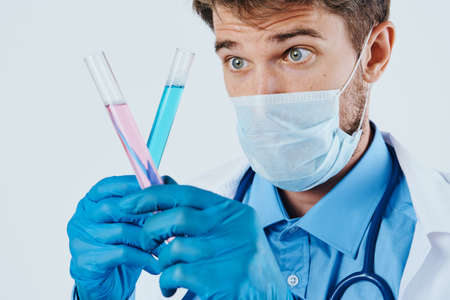 Man with a beard on a white isolated background holds test tubes for experiments, science, scientist, doctor.の写真素材