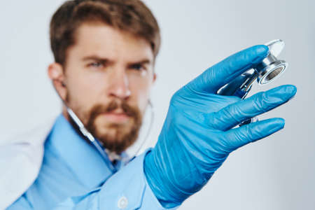 Man with a beard on a white background in medical gloves, doctor, medicine.