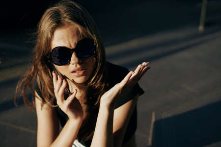 Young beautiful woman in sunglasses walking outdoors in the city, portrait.の写真素材