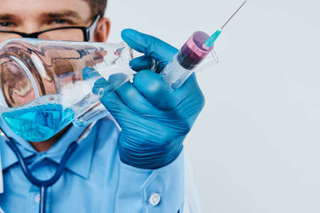 Man with a beard on a light background holds medical instruments, doctor, medicine.の写真素材