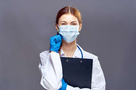 Doctor pediatrician in a medical mask with a folder tablet working in the hospital.の写真素材